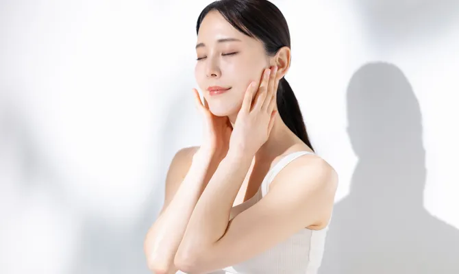 頬に手を当てて目を閉じている女性